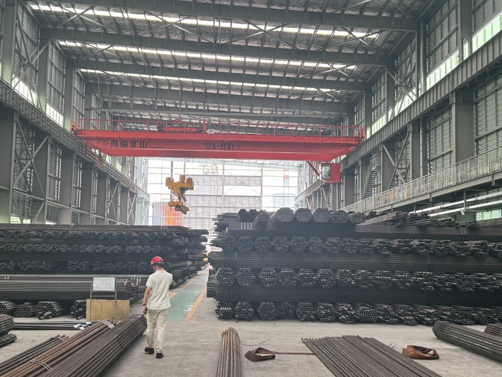 Overhead crane above stacked seamless pipe in a JURUN warehouse